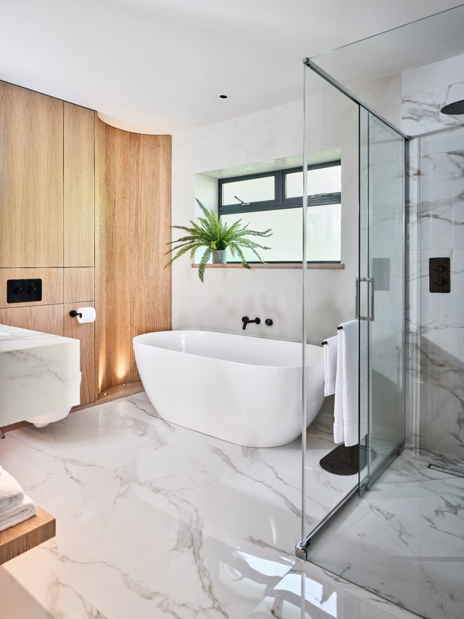 Modern bathroom featuring a freestanding tub, shower enclosure, and wooden accents.